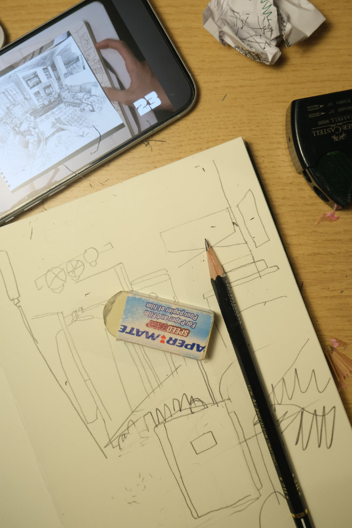 Sketchbook open on a desk with drawing tools